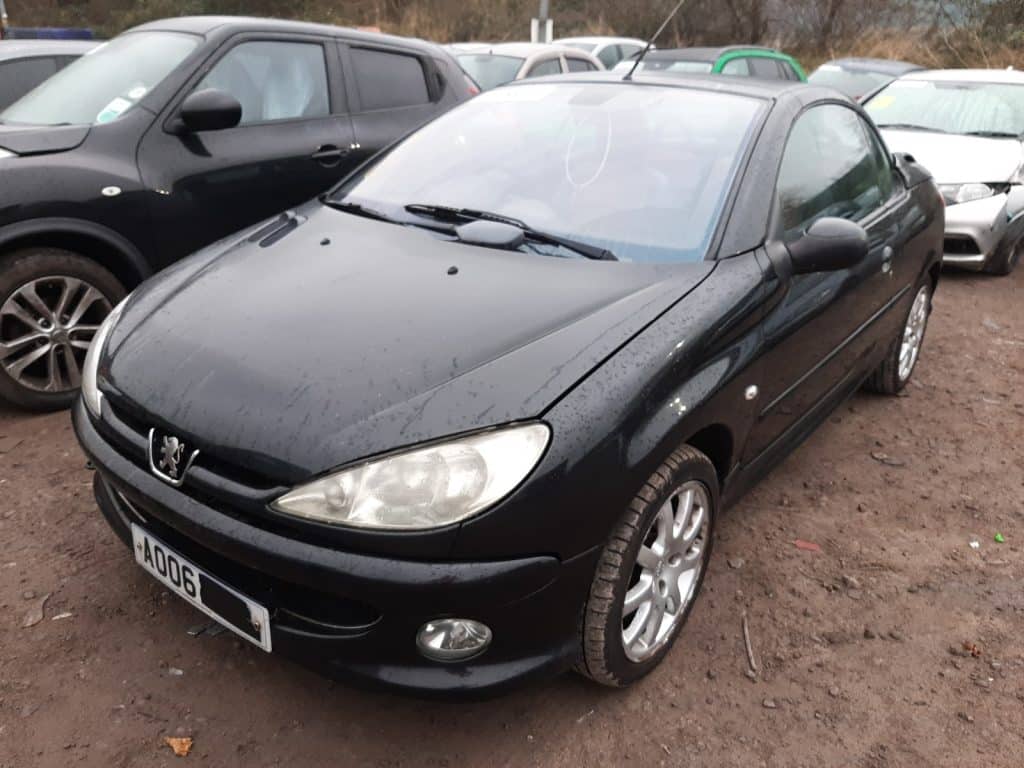 Side view of a parked black Peugeot 206