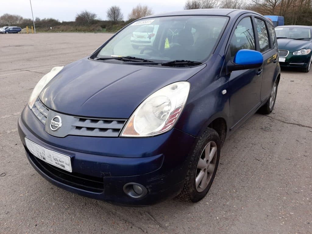 Front view of a parked blue Nissan Note